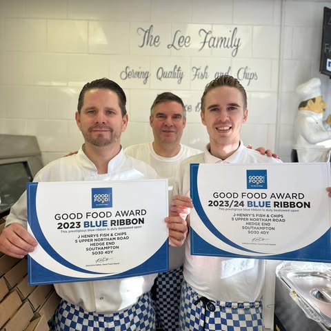 Three J-Henry's staff holding Good Food Award Blue Ribbon certificates for 2023 and 2023/24