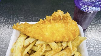 Golden battered fish and chips in a J-Henry's takeaway box